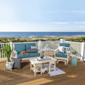 White poly glider loveseat, glider chair, side table and coffee table with teal cushions on a beachfront deck