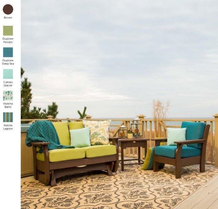 Brown poly patio chair with teal cushions, side table and green cushioned glider loveseat on an oceanfront deck