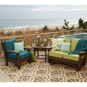 Brown poly patio chair with teal cushions, side table and green cushioned glider loveseat on an oceanfront deck