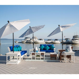 Marina dock lounge with white poly sofas, royal blue cushions, teal pillows, side tables and three market umbrellas
