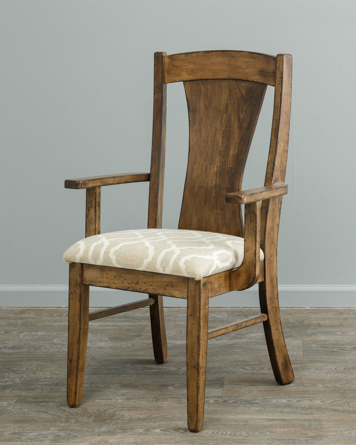Rustic dining arm chair with a shaped back panel, flat plank arms and a cream patterned cushioned seat on gray flooring