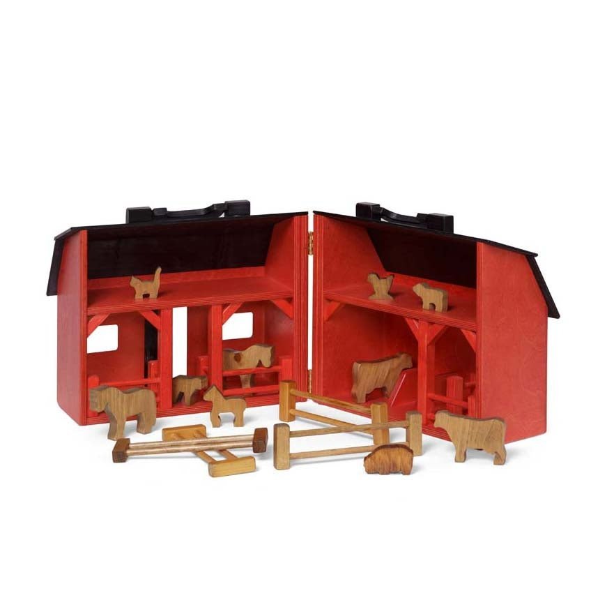 Red painted wooden folding toy barn closed into a carry case with a black gambrel roof, handle and cutout windows