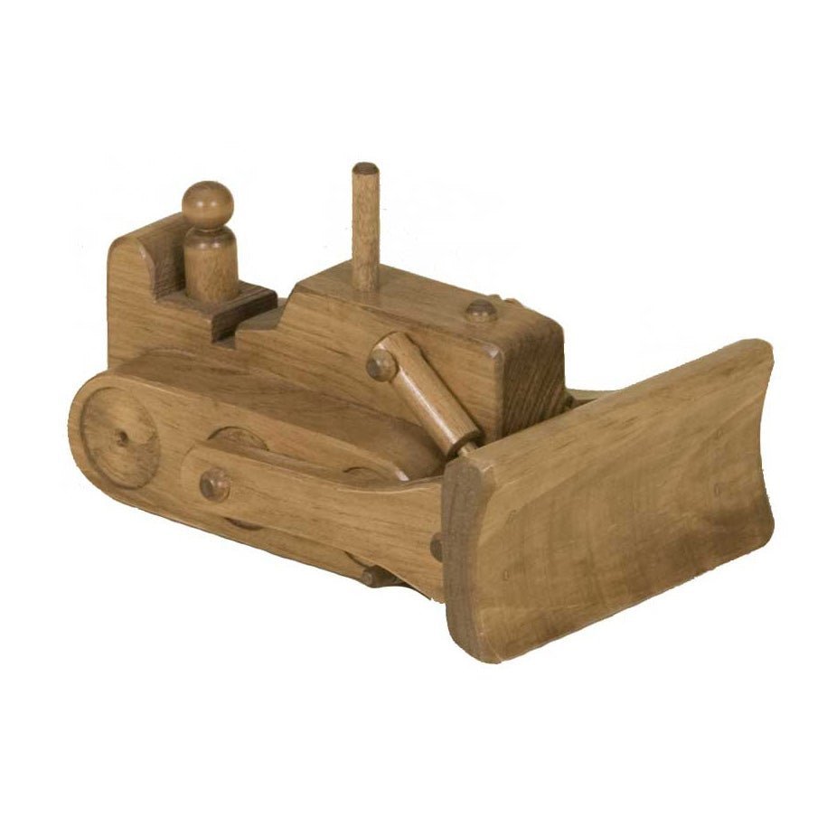 Girl pushing a yellow wooden toy bulldozer with black blade toward a stack of wooden building blocks