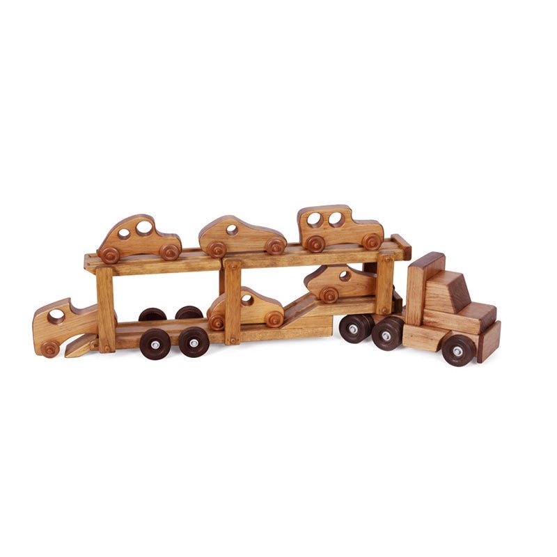 Boy loading small wooden cars onto a two-level wooden car carrier truck toy on a living room rug