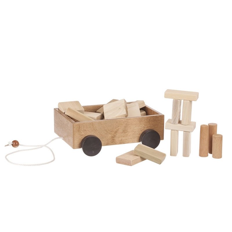 Red painted wooden pull wagon filled with natural wood building blocks, with black wheels and a pull cord