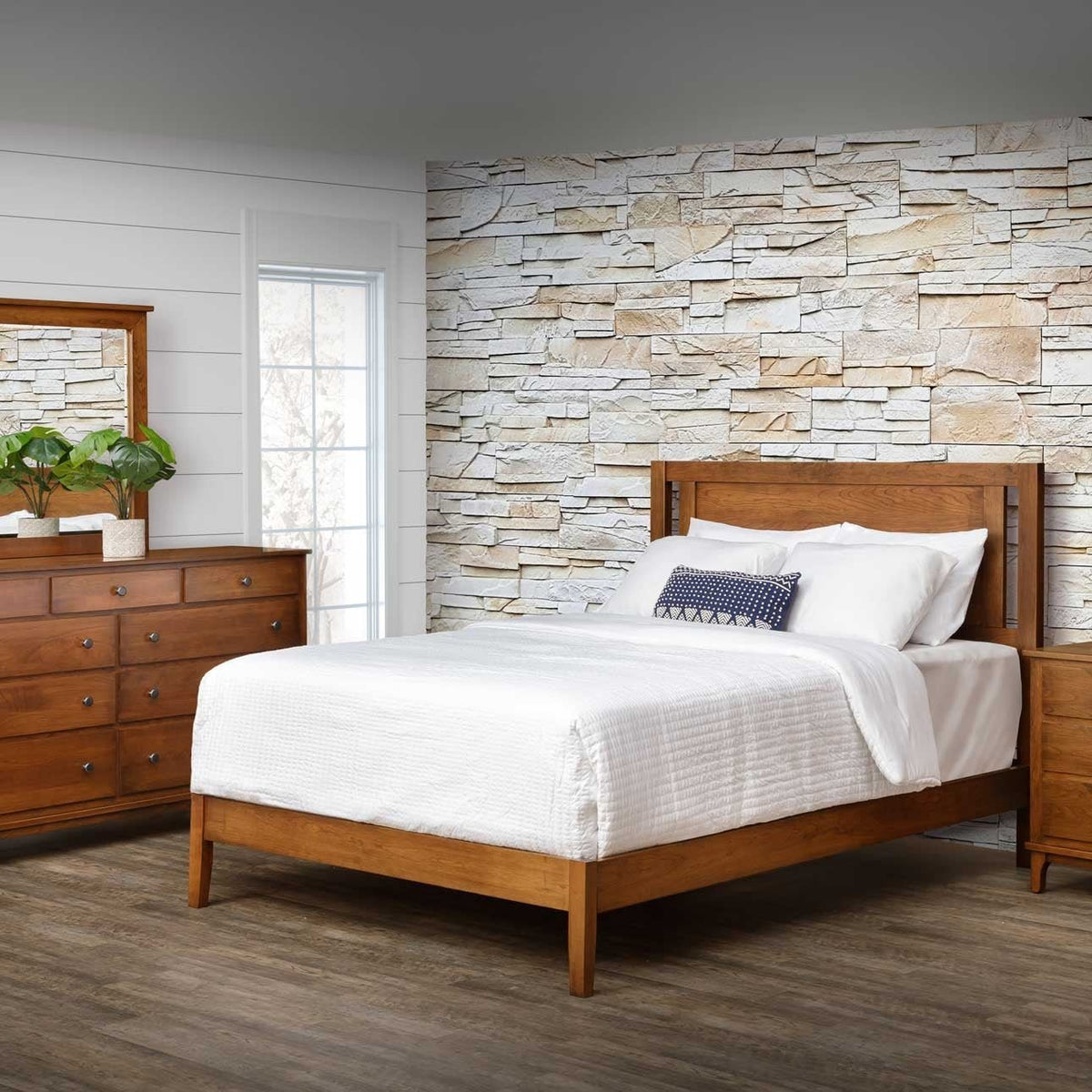 Open panel bed in light chestnut wood staged with white bedding against a stacked stone wall and shiplap bedroom