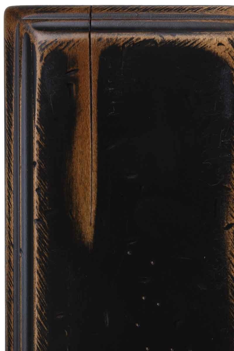 Antiquated Black on maple, a distressed black painted panel corner where sanded edges reveal warm brown wood underneath