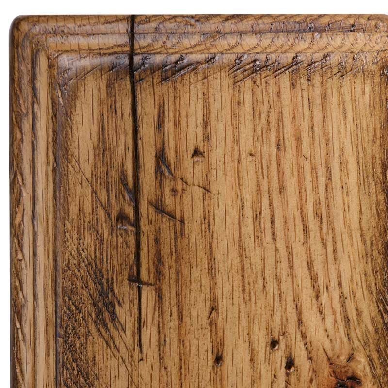 Rustic oak in Antiquated Natural, warm tan finish showing cathedral grain, a check along the corner and hand-punched worm holes