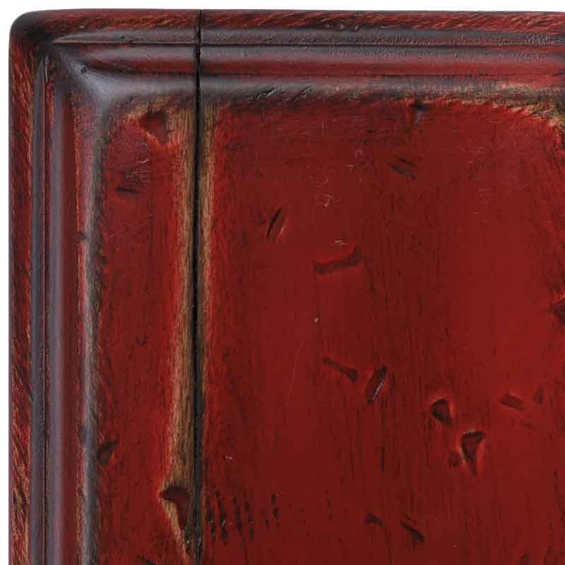 Close view of the Antique Red maple swatch, rich red paint with rub-through along the molded corner and scattered distress dents