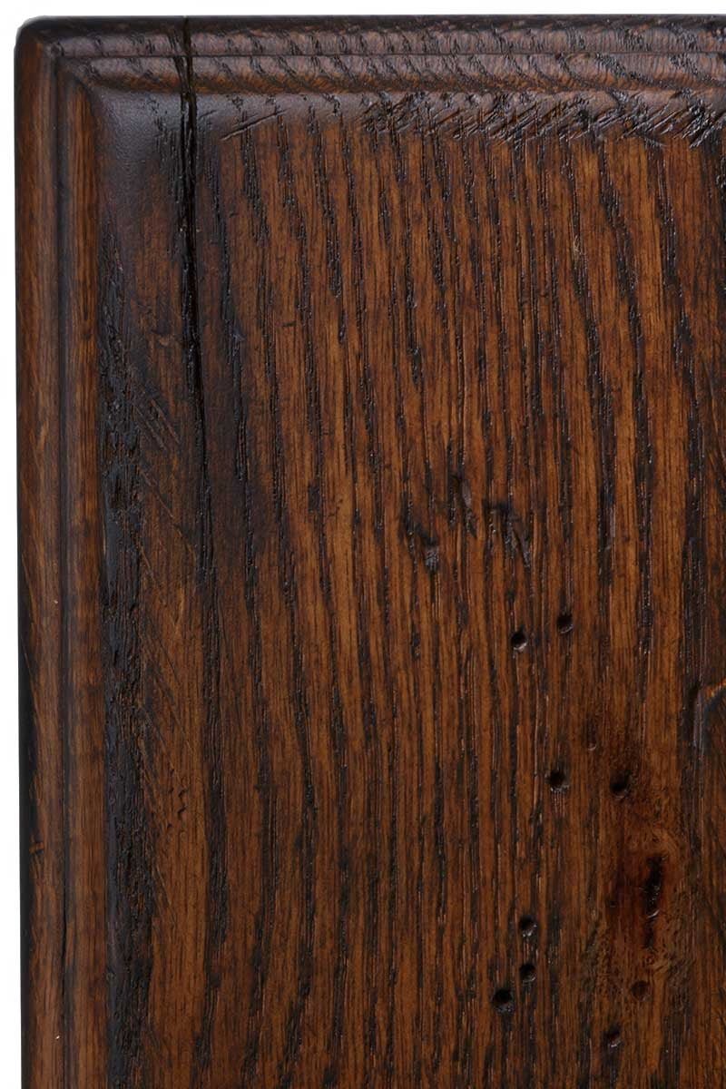 Antiquated Asbury on rustic oak, a warm reddish-brown panel with dark open grain, worm holes and blackened molded edges