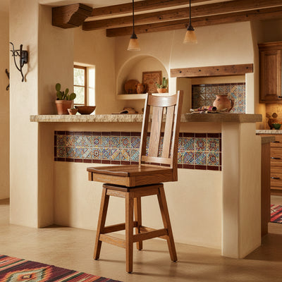 Oak swivel bar stool with slat back and square seat in a southwestern kitchen with tiled counter and pendant lights