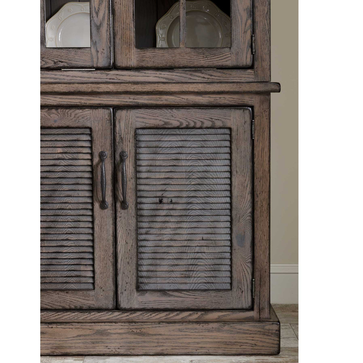 Weathered oak hutch base detail with two louvered doors, hand-forged iron pulls and glass upper doors above