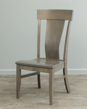 Gray stained lumbar dining chair with shaped solid back panel, flared crest rail and contoured saddle seat on wood flooring