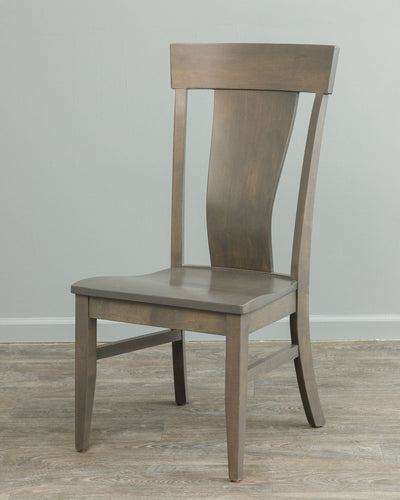 Gray stained lumbar dining chair with shaped solid back panel, flared crest rail and contoured saddle seat on wood flooring