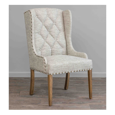 Cream tufted wing back dining arm chair with bronze nailhead trim and weathered oak tapered legs