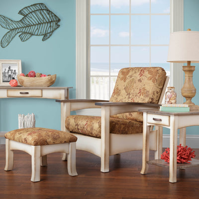 Coastal Morris chair with floral cushions and cream painted frame paired with an ottoman in a beach themed room
