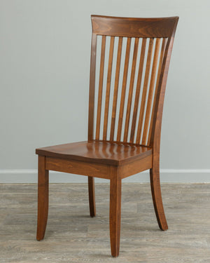 Front view of a brown maple dining chair with tall vertical slat back, curved crest rail and scooped saddle seat