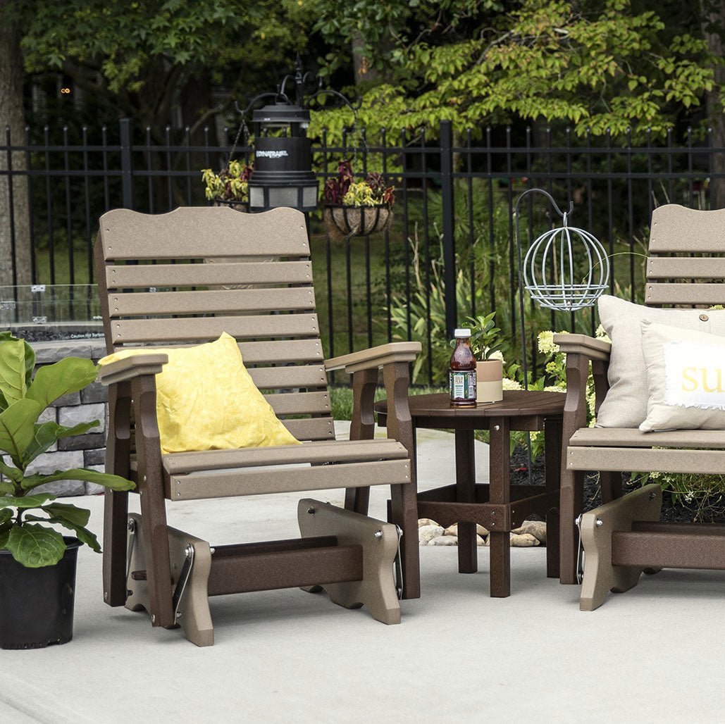 Two weatherwood and brown poly curve back gliders with pillows flanking a small round side table on a patio