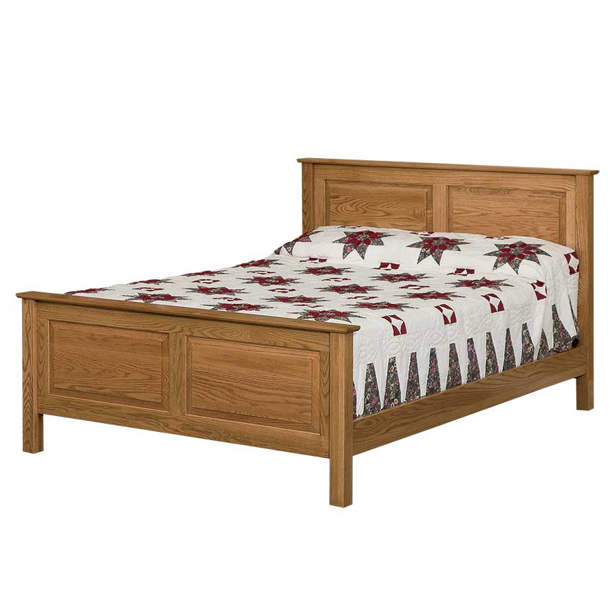 Raised panel oak bed with a two-panel headboard and matching footboard, dressed in a red star quilt