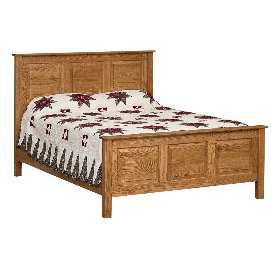 Solid oak three panel bed with clean square posts and a quilted poinsettia bedspread on a white background