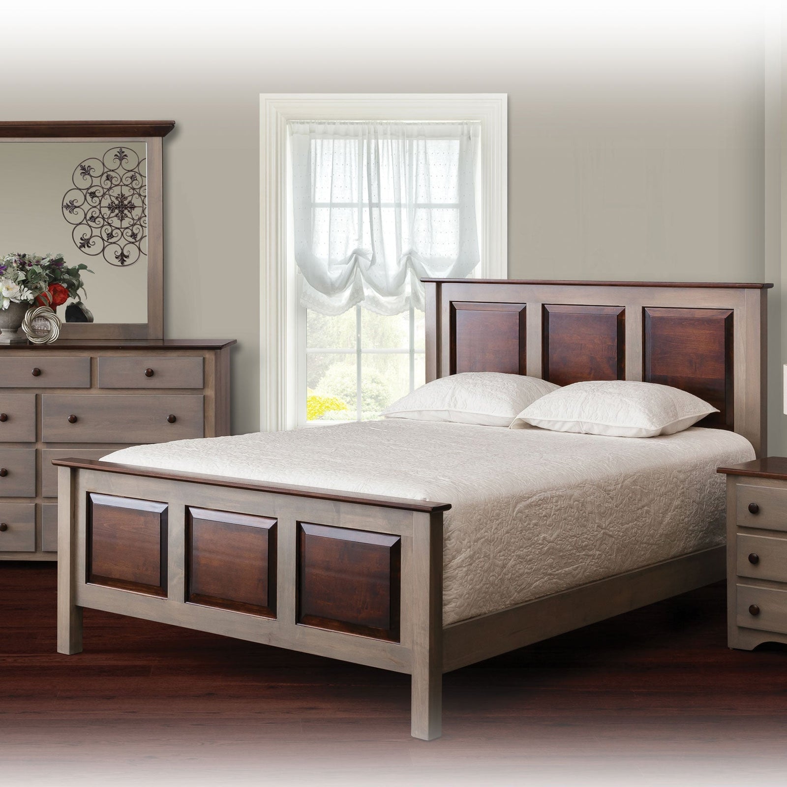 Gray and cherry two tone panel bed in a bright bedroom with matching dresser, mirror and white bedding