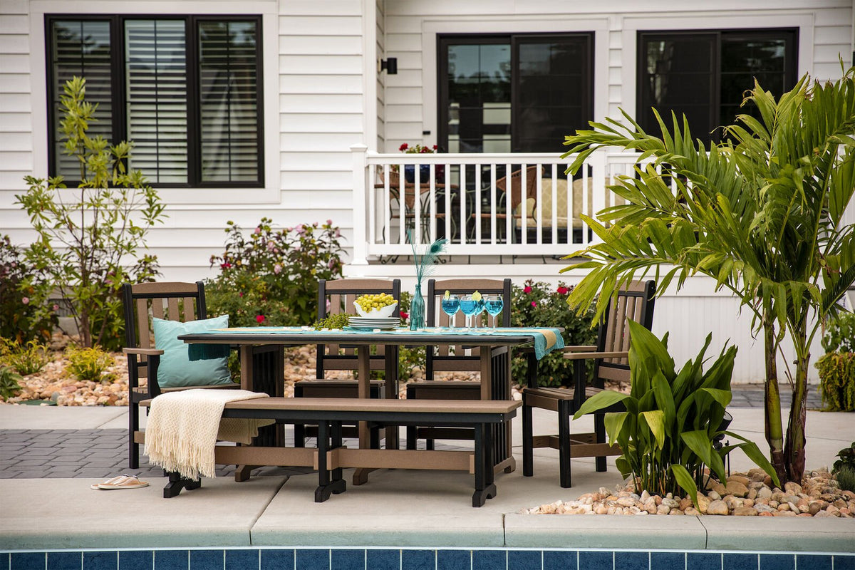 Brown and black poly patio dining set with four chairs and a bench, table set with teal linens beside a pool