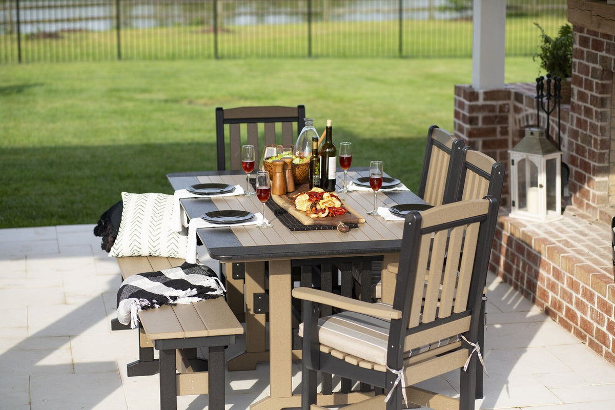 Weatherwood and gray poly rectangular dining table set with wine and charcuterie, chairs and bench on a patio