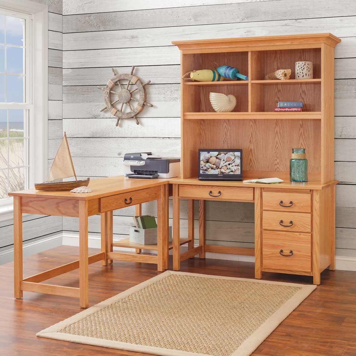 Coastal styled office with an oak desk, tall open hutch and matching writing table against white shiplap walls