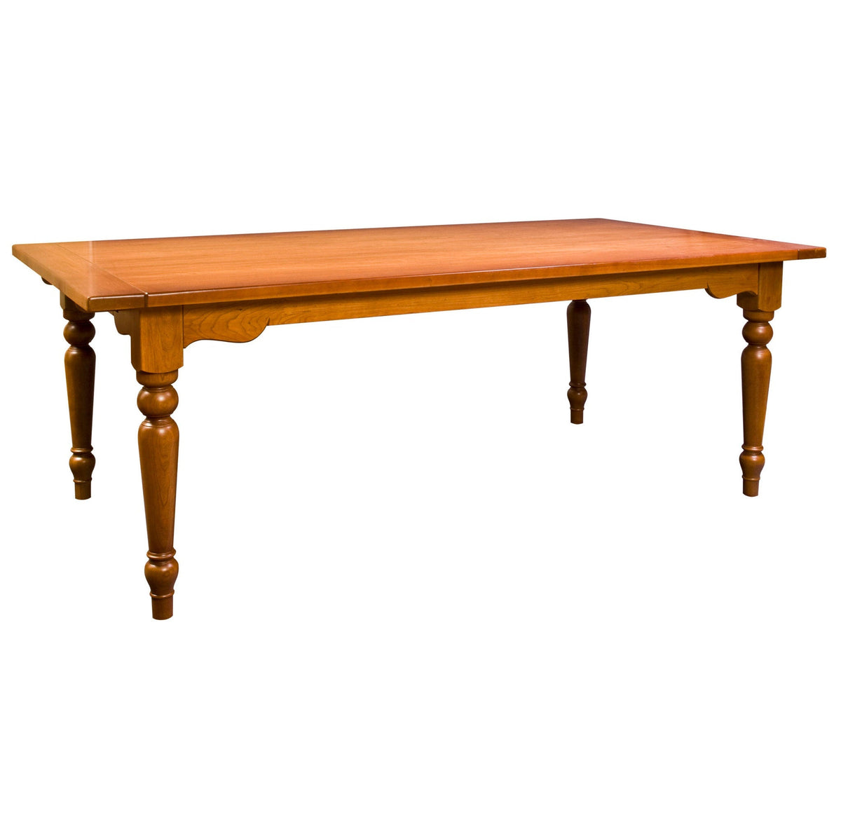 Long farmhouse dining table in a honey cherry finish with a scalloped apron and chunky turned legs