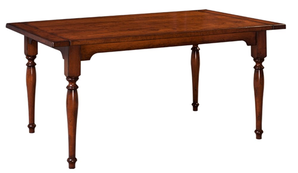 Solid wood farmhouse table with a plank top, shaped apron and four turned legs in a warm medium brown finish
