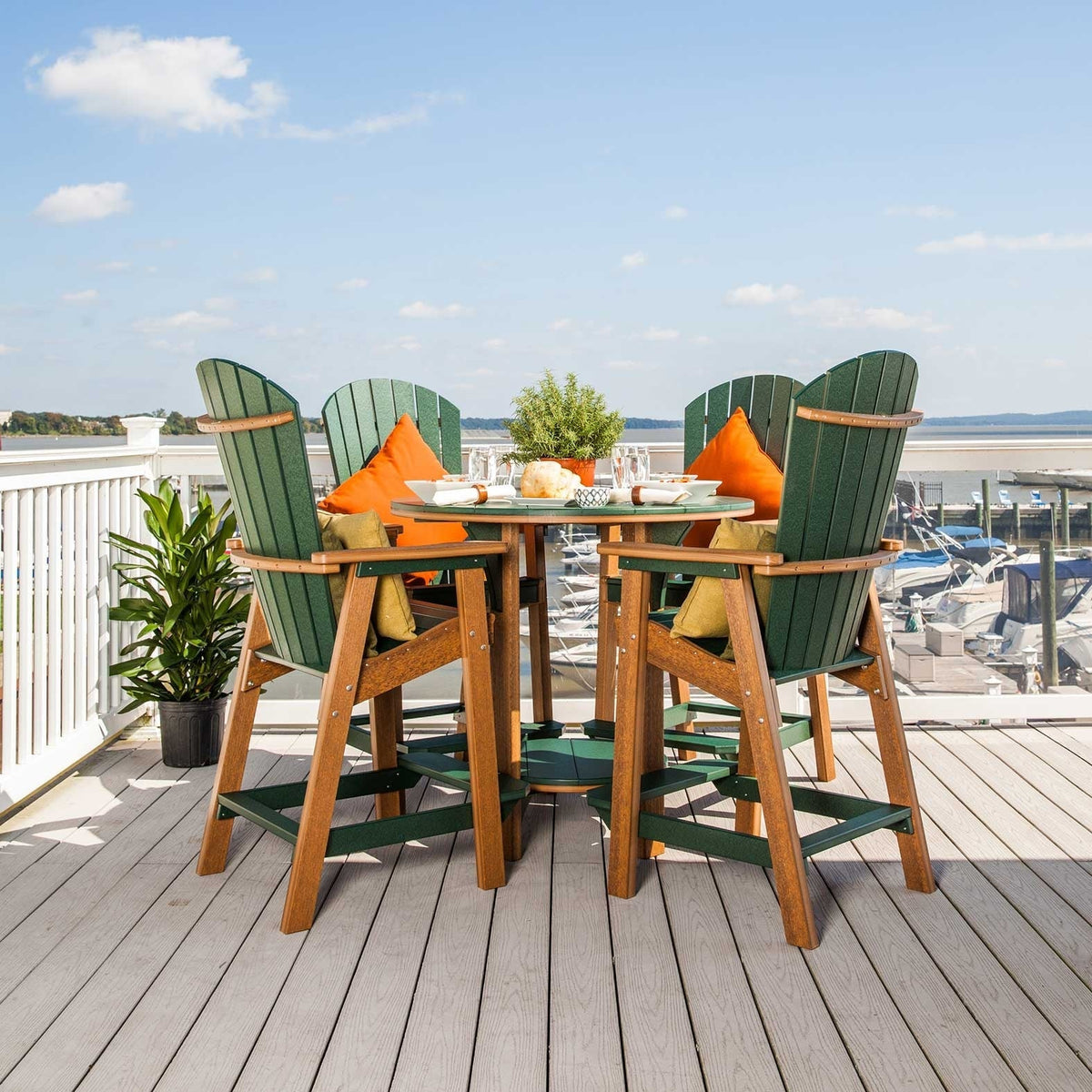 Green Adirondack style poly bar chairs with cedar frames around a round bar table on a waterfront deck