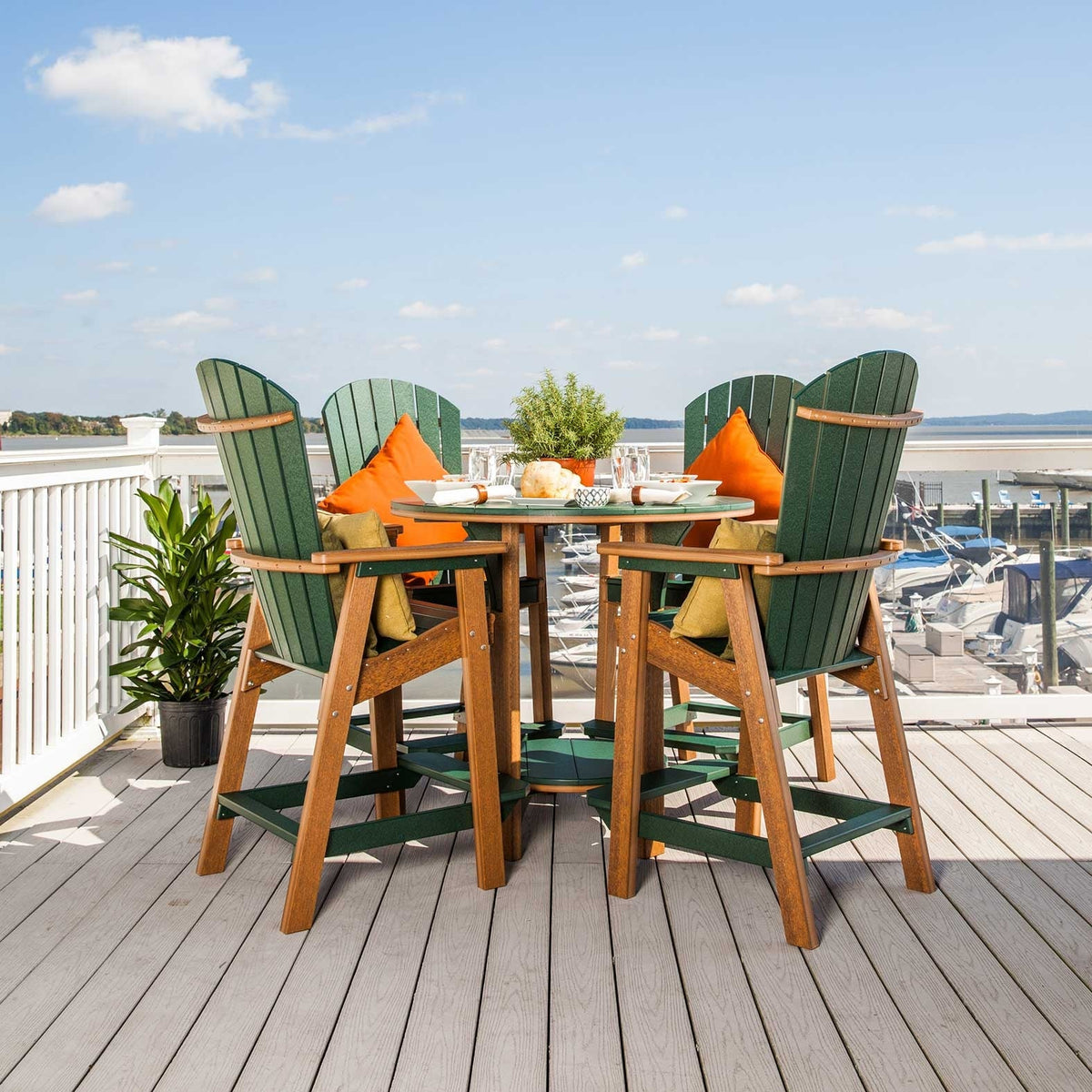Green Adirondack style poly bar chairs with cedar frames around a round bar table on a waterfront deck