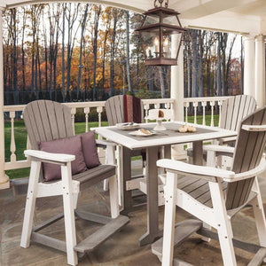 Driftwood gray and white poly bar table with four tall Adirondack chairs on a stone porch in autumn