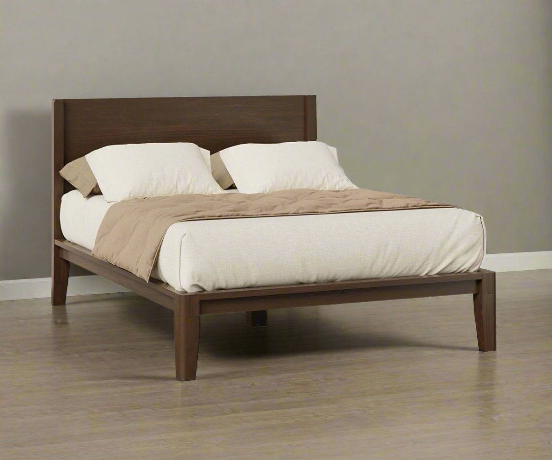 Dark espresso stained platform bed with a flat wood panel headboard and neutral bedding on light wood flooring