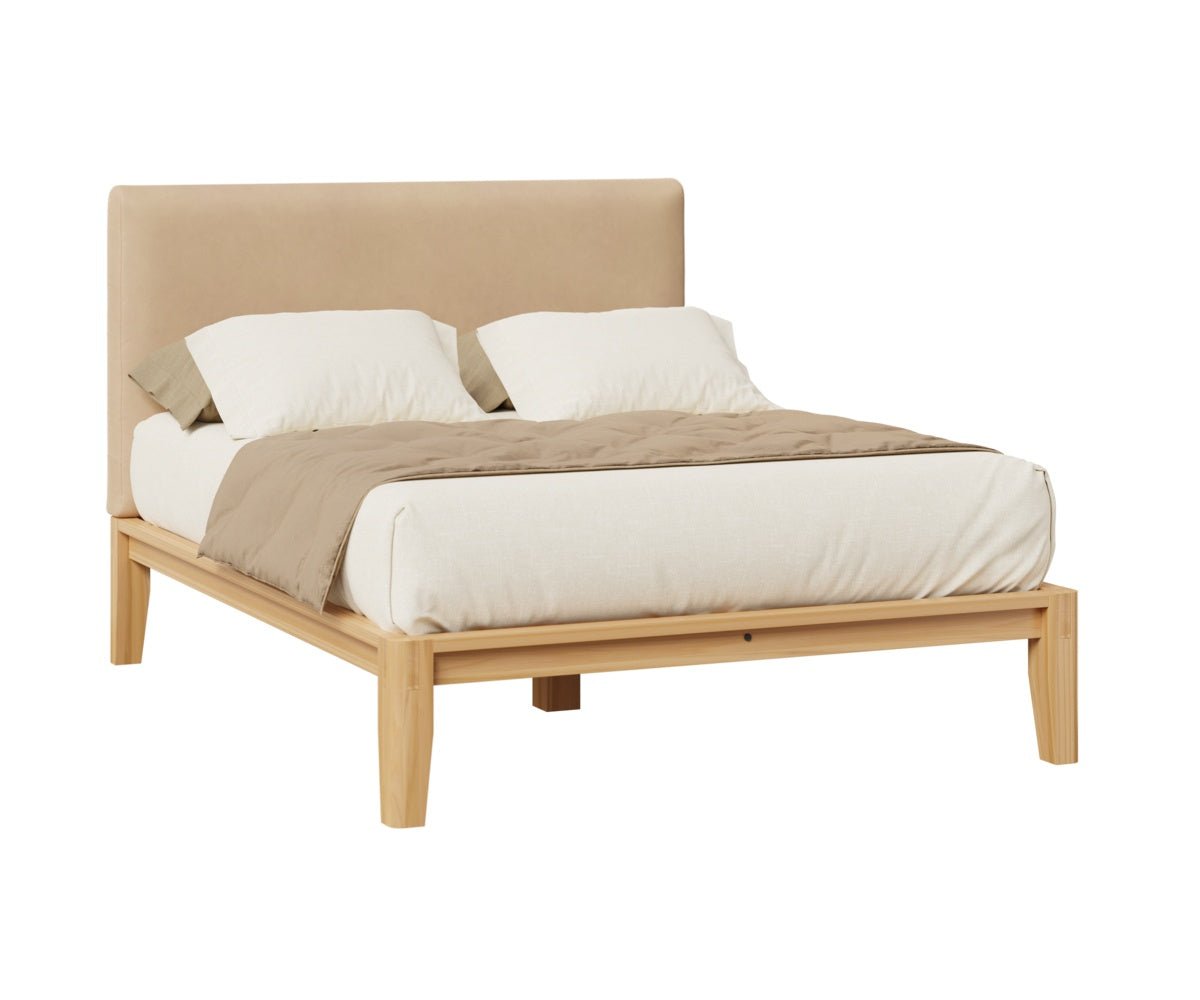 Natural wood platform bed with a tan velvet upholstered headboard, cream duvet and taupe throw on a white background