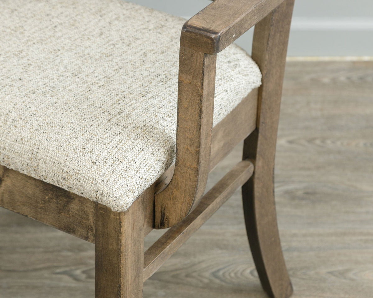 Close-up of the X back arm chair showing the oatmeal woven seat, arm support joint and rustic brown finish