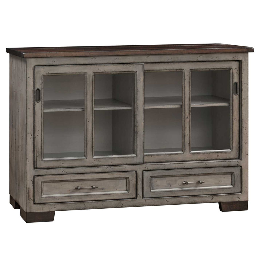 Distressed gray server with two sliding glass doors, open shelves inside, walnut top and two drawers with bar pulls