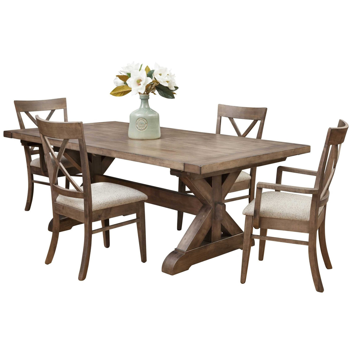 Weathered gray trestle dining table with X base, four X back chairs including arm chairs and a floral centerpiece