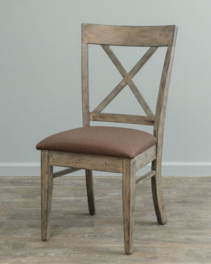 Weathered driftwood X back dining chair with a rust brown fabric seat and tapered legs on wood flooring