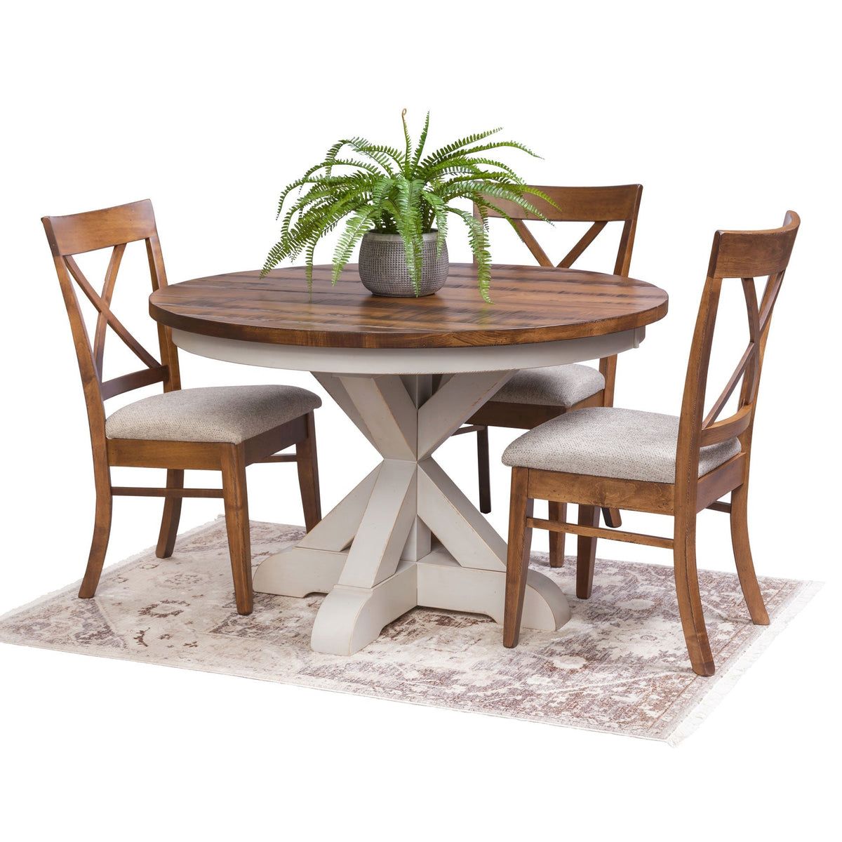 Round pedestal table with rustic oak top and white X base with three X back chairs with gray fabric seats on a rug