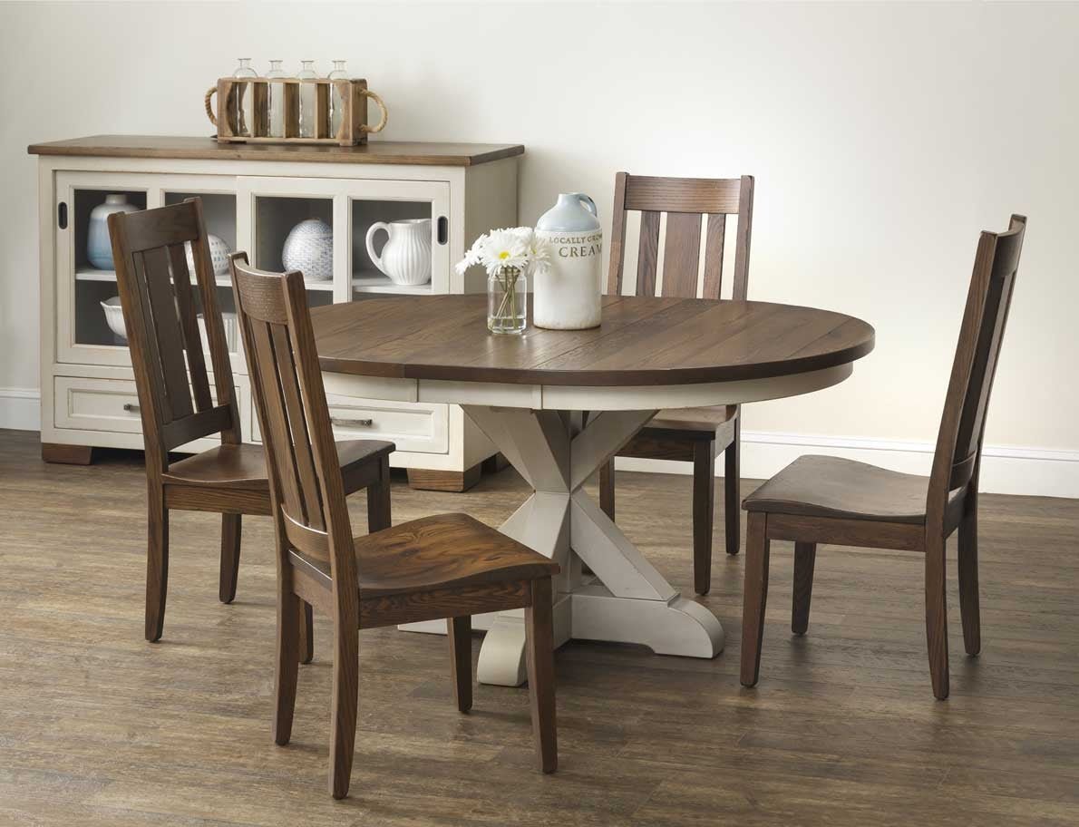 Two-tone round pedestal table with wide plank oak top and cream X base, styled with daisies and slat back chairs