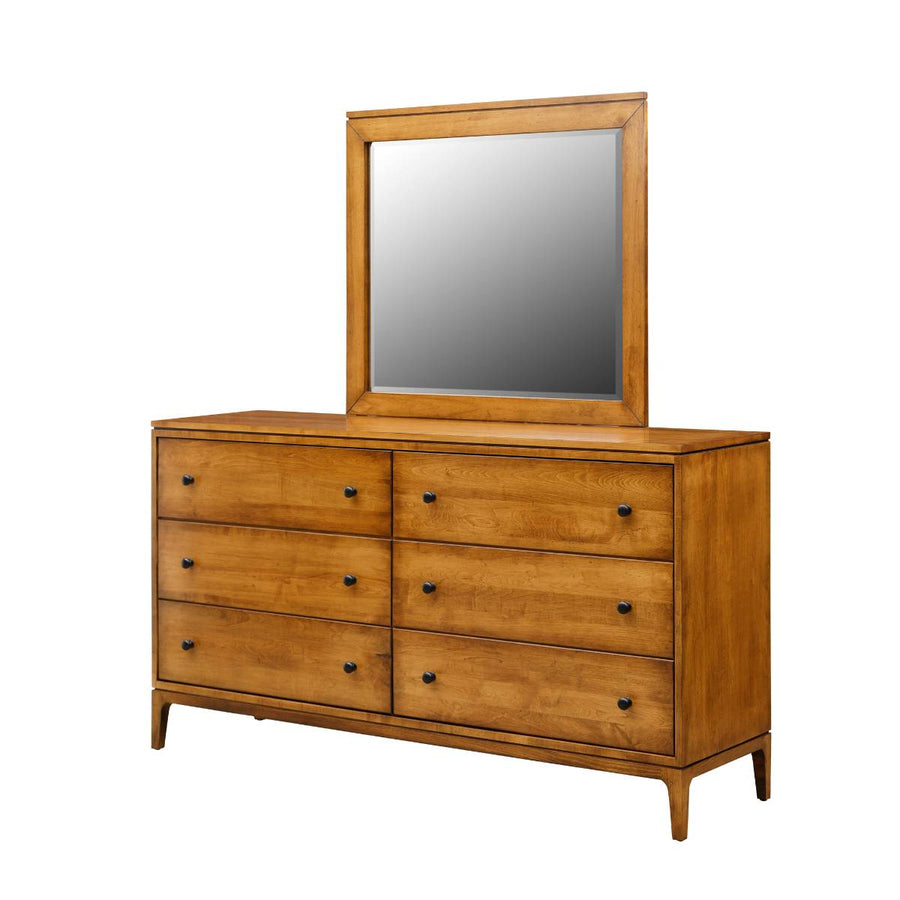 Solid maple triple dresser with six drawers, black round knobs, tapered legs and a square framed mirror on a white background