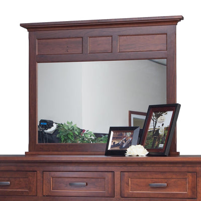 Wide cherry dresser mirror with paneled header and crown molding shown on a nine-drawer dresser with photo frames