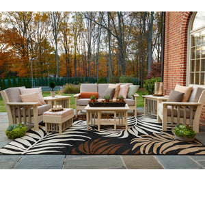 Ivory poly mission patio seating group with gray cushions, ottomans and coffee table on a patterned rug in fall