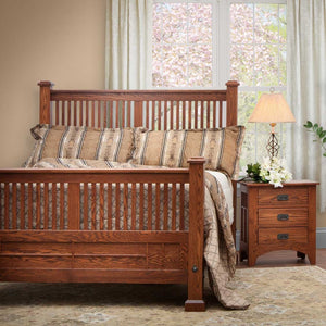Mission oak spindle bed with slatted headboard and footboard, dressed in striped bedding beside a nightstand