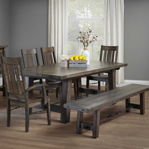 Gray Ouray iron buckle trestle table with plank top and bench, slat back chairs and cotton stems in a dining room