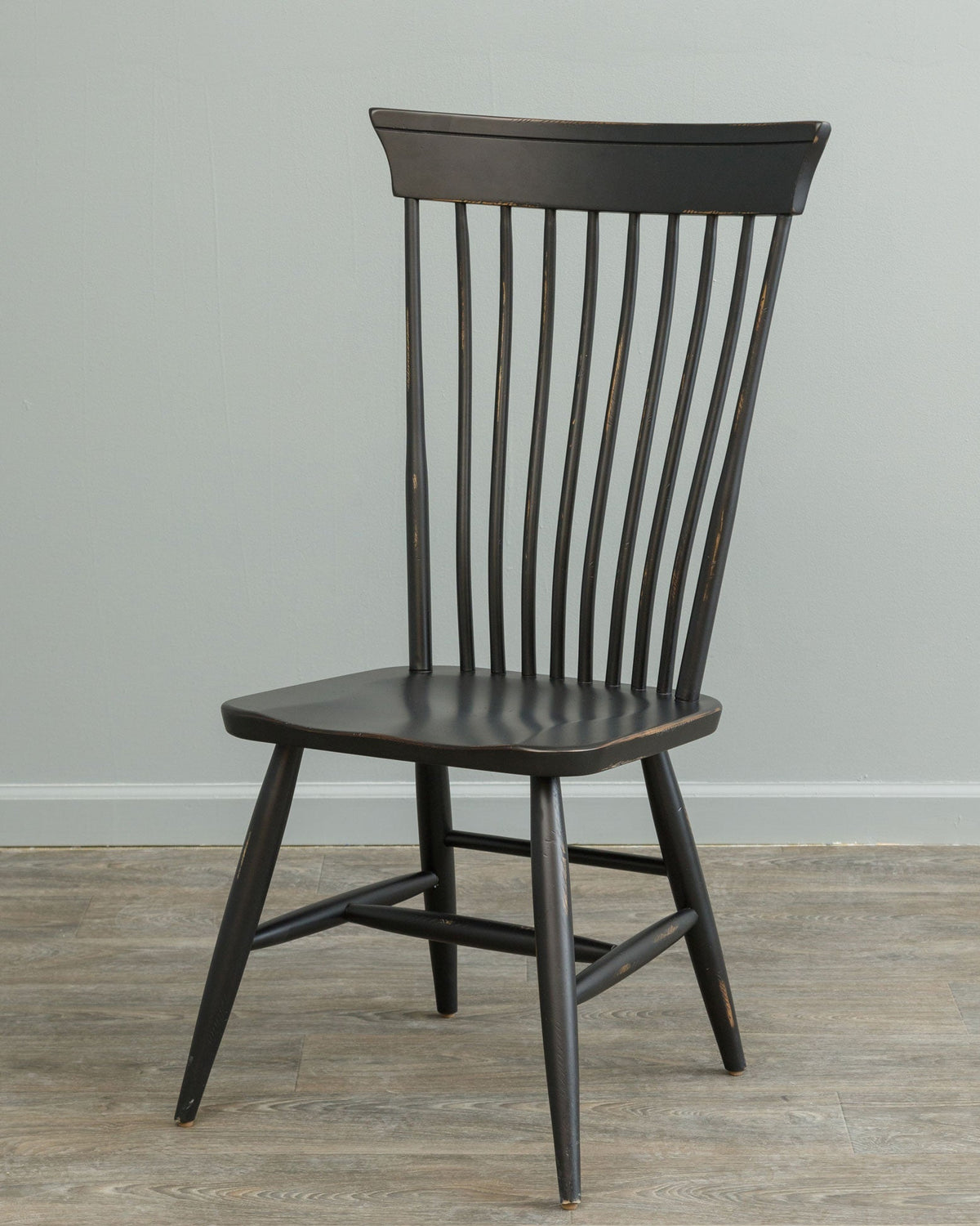 Distressed black Windsor dining chair with nine spindle back, curved crest rail, saddle seat and splayed turned legs