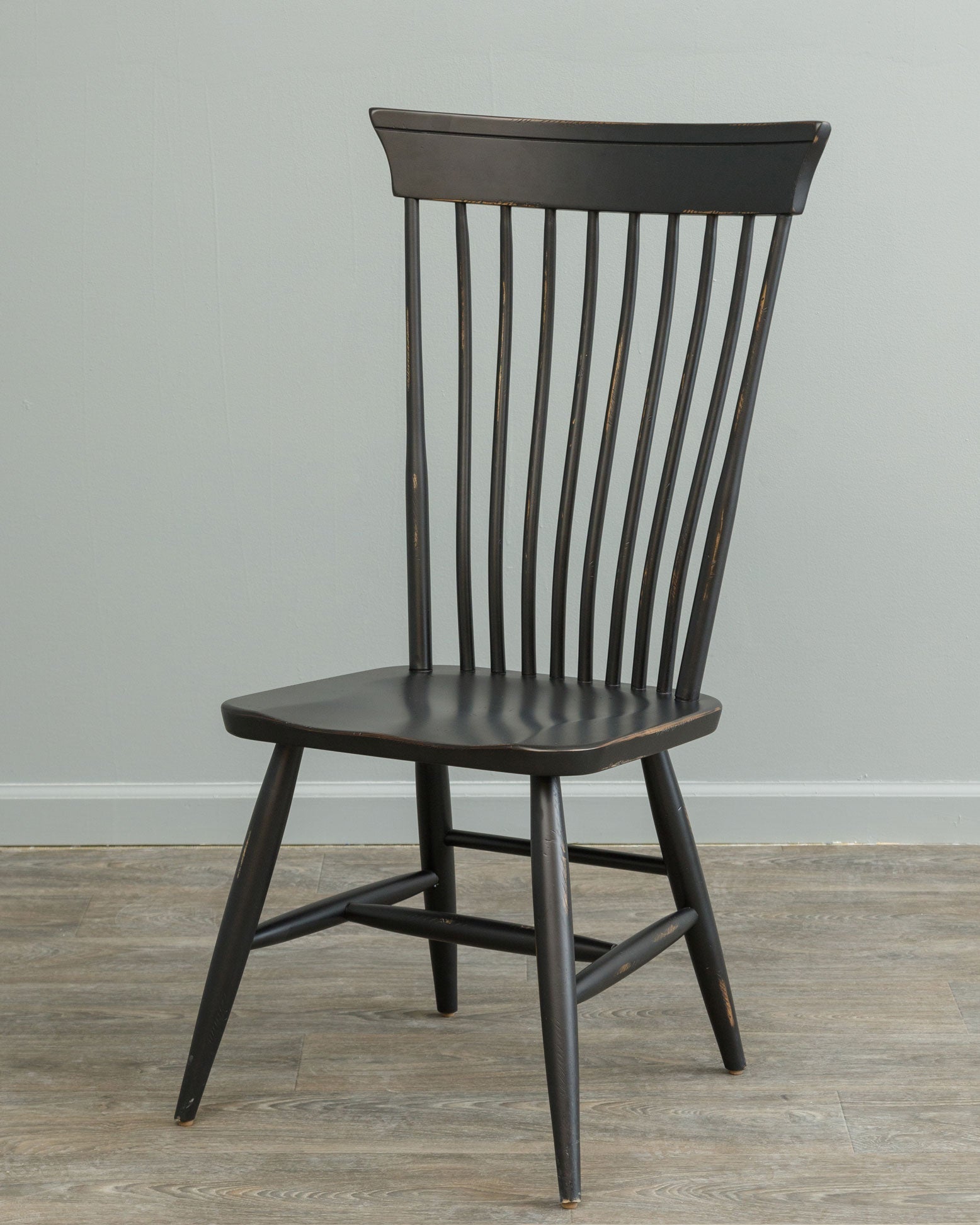 Distressed black Windsor dining chair with nine spindle back, curved crest rail, saddle seat and splayed turned legs