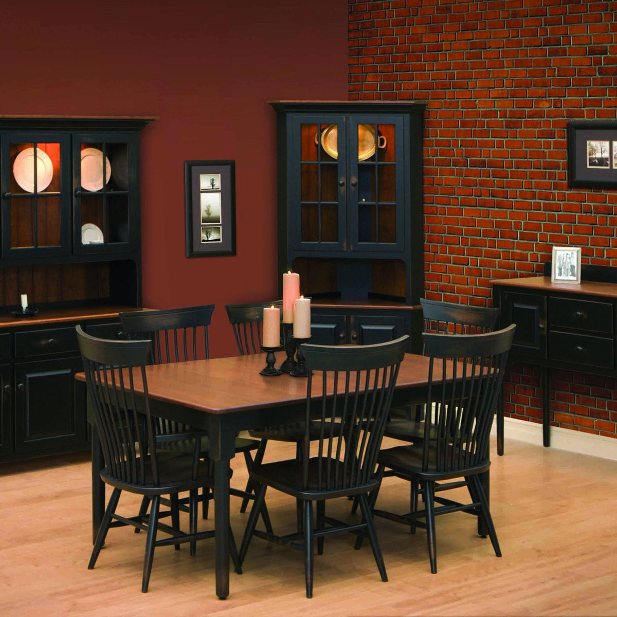 Colonial dining room with black Windsor chairs, oak topped table, corner hutch and sideboards against brick