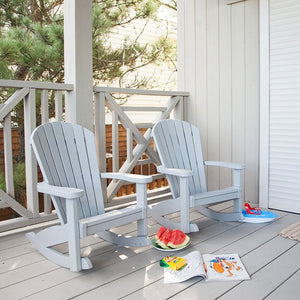 Two light gray child size Adirondack rocking chairs on a porch with watermelon slices and a coloring book